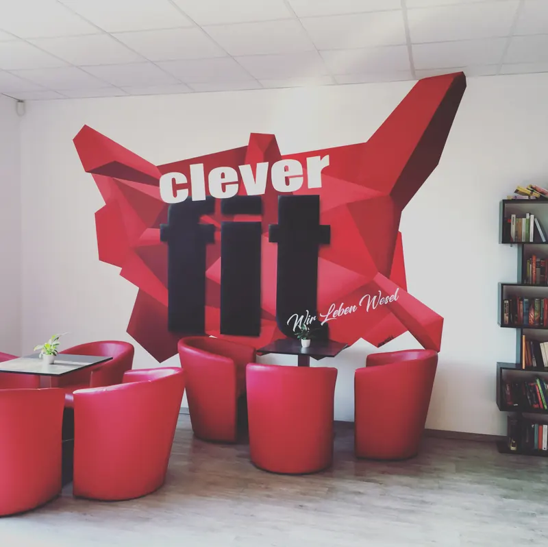 Lounge eines Fitnessstudios mit großer roter Polygon-Grafik und Logo, gestaltet von Dagobert Lack
