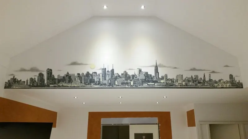 Schmale Großstadt-Skyline in Grautönen unter einer Dachschräge über einem Durchgang
