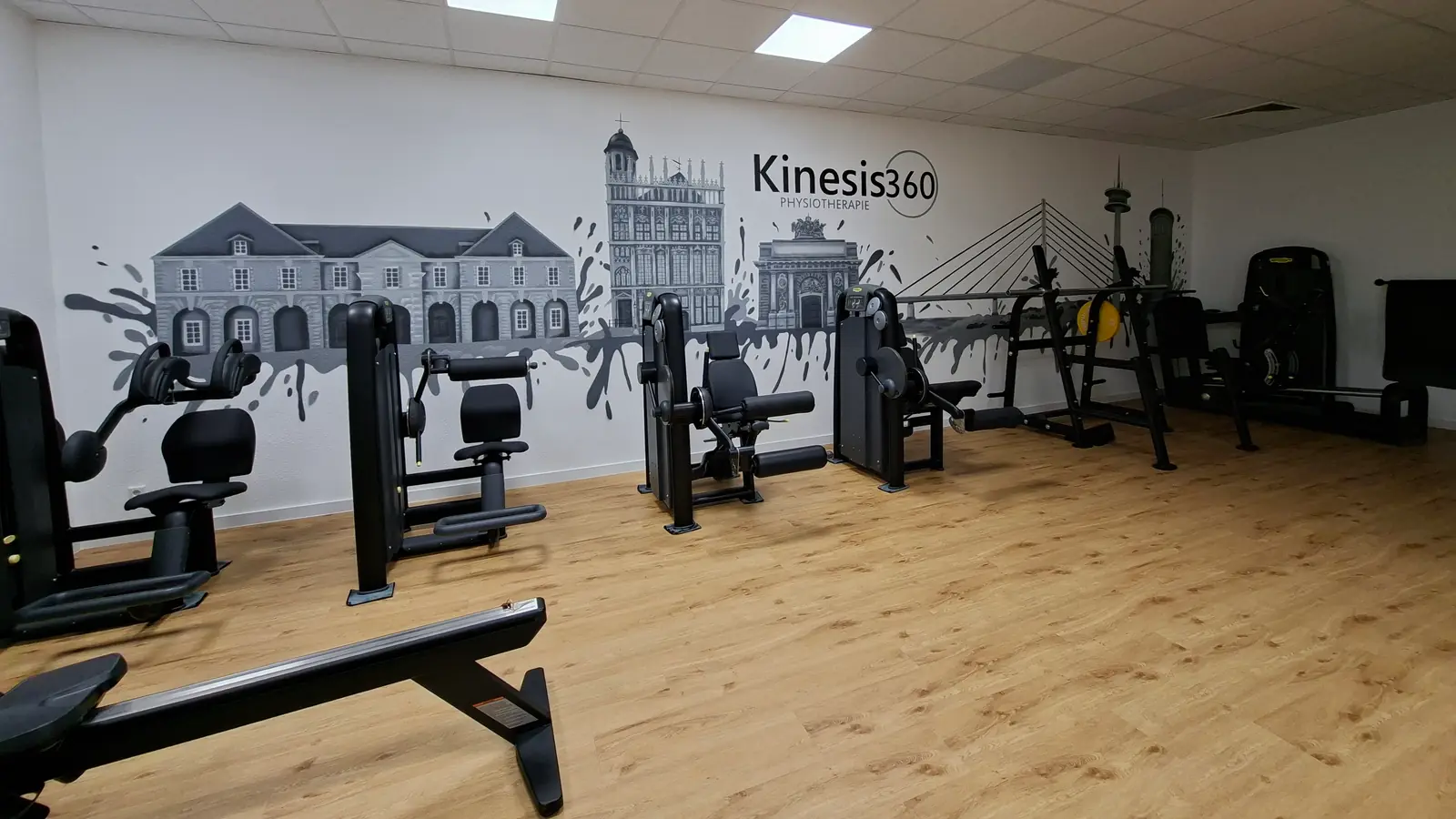 Stadtsilhouette in Grautönen von Dagobert Lack über die ganze Wand eines Trainingsraums